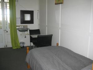 sypialnia z łóżkiem, umywalką i stołem w obiekcie Australian Hotel Winton Budget Hotel Accommodation w mieście Winton