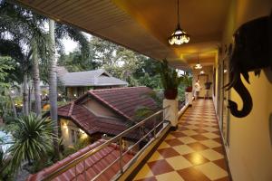 a balcony of a house with a checkered floor at Liam's Guesthouse Adults Only in Chiang Mai