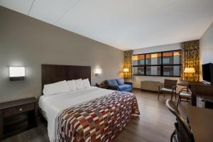 um quarto de hotel com uma cama e uma sala de estar em Gateway Inn em Merrick