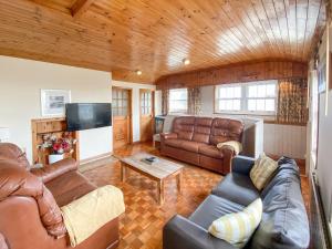 sala de estar con muebles de cuero y TV de pantalla plana en Mariners Lodge en Felixstowe