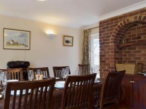 uma sala de jantar com mesa e cadeiras e uma parede de tijolos em Mariners Lodge em Felixstowe