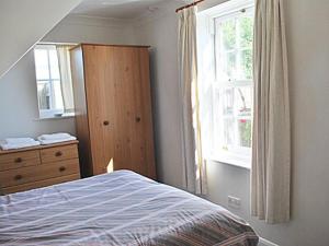 a bedroom with a bed and a dresser and a window at Mariners Lodge in Felixstowe