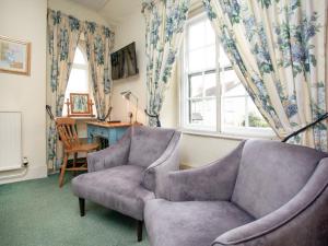 a living room with a couch and a chair at Lifton Hall - Sycamore in Lifton