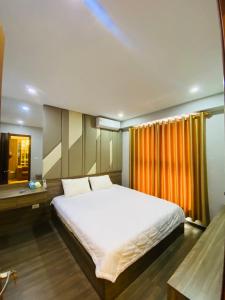 Un dormitorio con una cama blanca grande y una ventana en Homestay Bãi Cháy HaLong 1 2 3 5 phòng ngủ Liên hệ em tư vấn, en Ha Long