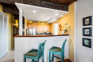 una cocina con 2 sillas en un bar en Kona Mansions D231, en Kailua-Kona