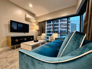 a living room with a blue couch and a large window at The Platinum 2 Kuala Lumpur by HOLMA in Kuala Lumpur