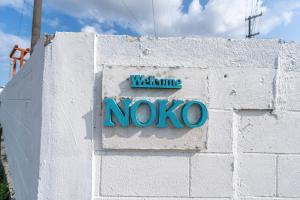 a sign on a wall that says welcome novo at private house noko in Miyako Island