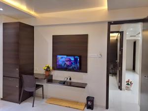 a bathroom with a sink and a tv on a wall at Bouquet Residency in Nashik