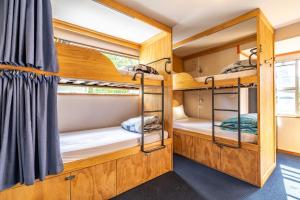 a room with bunk beds in a bus at The Flaming Kiwi Backpackers in Queenstown