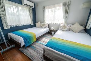 a bedroom with two beds with rainbow at private house noko in Miyako Island