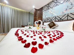 a bed with a bunch of red roses on it at Cửa Đông Luxury Hotel in Vinh