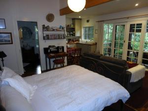 1 dormitorio con 1 cama y sala de estar en Stone's Throw Cottage Bed and Breakfast, en Belgrave