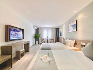 JianyangにあるHoliday Inn Guoshangのベッド2台とテレビが備わるホテルルームです。