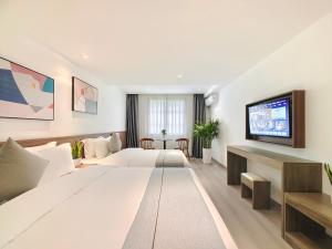 a hotel room with a large bed and a flat screen tv at Holiday Inn Guoshang in Jianyang