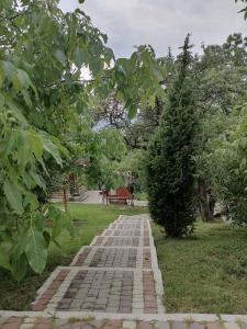 einen Ziegelweg in einem Park mit einem Baum in der Unterkunft Lavender Valley in Perekrestnoye
