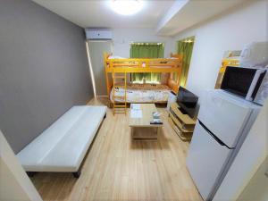 Kleines Zimmer mit einem Bett und einem Kühlschrank. in der Unterkunft Comfort CUBE PHOENIX S Kumamoto in Kumamoto