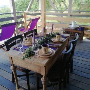 einen Holztisch mit Tellern und Weingläsern darauf in der Unterkunft Lavender Valley in Perekrestnoye
