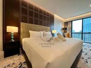 a hotel room with a large bed with a sign on it at The Platinum 2 Kuala Lumpur by HOLMA in Kuala Lumpur