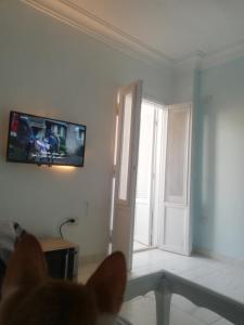 uma sala de estar com televisão na parede em غرفة مفروشة خاصة الشيخ زايد للرجال فقط em Sheikh Zayed