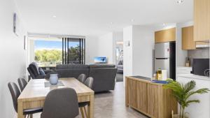 Il comprend une cuisine et un salon avec une table et des chaises. dans l'établissement Modern Unit On The Marina, à Sandstone Point