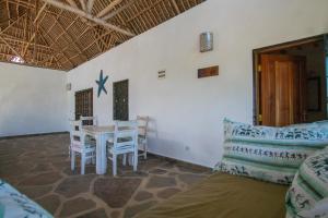 uma sala de estar com mesa e cadeiras em Rafiki Village em Watamu