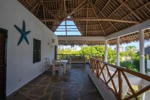 a porch of a house with a table and chairs at Rafiki Village in Watamu