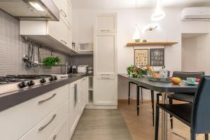 a kitchen with white cabinets and a black counter top at Laura Five Senses in Florence