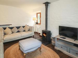 a living room with a couch and a fire place at 1 The Barn in Haverfordwest
