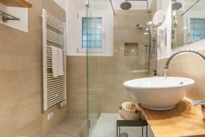 La salle de bains est pourvue d'un lavabo et d'une douche en verre. dans l'établissement Laura Five Senses, à Florence