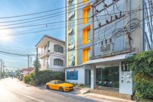 a orange car parked in front of a building at G1 Touch Blue Sky in Kamala Beach