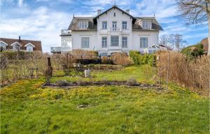 a large white house on top of a green yard at Amazing Home In Hellebk With Wifi And 2 Bedrooms in Hellebæk