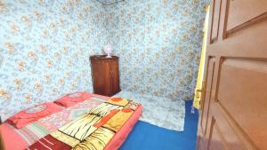 a small bedroom with a bed and blue walls at Penginapan Syariah Dhifa Indonesian only in Bukittinggi