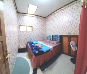 a bedroom with a bed in a room with wallpaper at Penginapan Syariah Dhifa Indonesian only in Bukittinggi