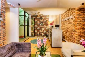 a living room with a couch and a brick wall at Bata Merah Boutique Hotel in Banting