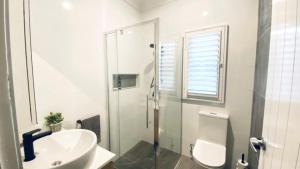 Un baño blanco con inodoro y lavabo. en Stay Salty on Bribie Island, en Woorim 7 fotos más