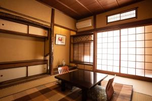 a room with a table and two chairs and a window at 城崎温泉 旅館 つばき乃 - Kinosaki Onsen Ryokan Tsubakino in Toyooka
