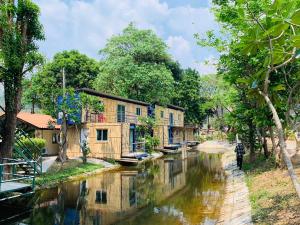 un hombre caminando por un río en un pueblo en ปานีวิลล์ รีสอร์ต, en Ban Wang Takhrai