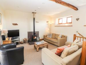 a living room with a couch and a fireplace at Swallow's Nest in Penrith