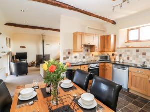 a kitchen with a wooden table and black chairs at Swallow's Nest in Penrith