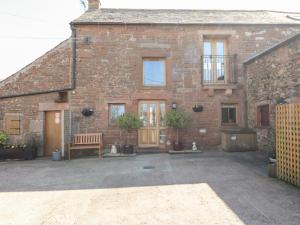 a brick house with a bench in front of it at Swallow's Nest in Penrith