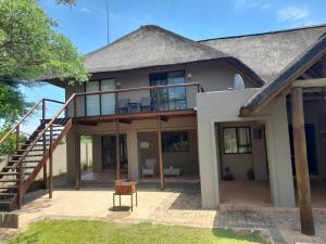 a house with a large deck and a staircase at Matori Lodge in Modimolle
