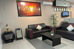 uma sala de estar com sofás e uma pintura na parede em SY JERANTUT HOTEL em Jerantut
