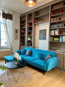 un sofá azul en una sala de estar con estanterías en Gîte Les Hauts de Boulogne en Boulogne-sur-Mer