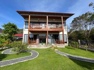ein Haus mit einem Balkon und einem Hof in der Unterkunft Lotus Home in Phu Quoc