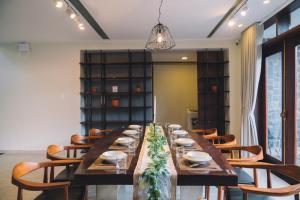 a long dining room with a long table and chairs at Bliss House- Golfvalley Đà Lạt in Da Lat +38 photos