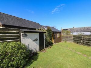 a backyard with a fence and a shed at Contention Barn in Perranzabuloe