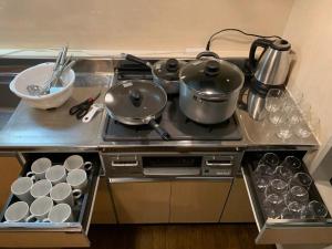 una cocina con fogones con ollas y sartenes. en SU House Yokohama 305 - Vacation STAY 13162 en Yokohama