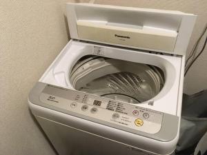 uma máquina de lavar roupa com a porta aberta num quarto em SU House Yokohama 305 - Vacation STAY 13162 em Yokohama