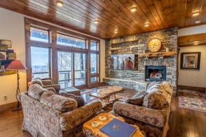 a living room with couches and a stone fireplace at Cardinal Perch in Beech Mountain