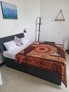 uma cama com um cobertor em cima em White City Villa em Nuwara Eliya